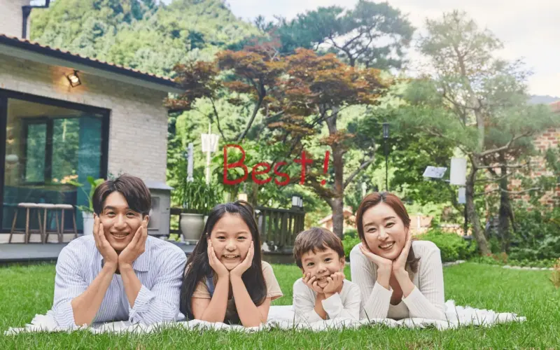초록 잔디밭 위 하얀 담요에 엎드려 환하게 웃는 네 가족의 행복한 모습. 가족 간 저가 양도 성공으로 얻은 안정과 화목을 보여주는 장면이다.